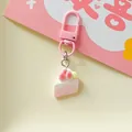 Close-up of cute simulation strawberry cake slice keychain with pink clasp charm - Triangle Cake