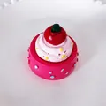 Detaillierte Makroaufnahme eines süßen 3D Miniatur-Kuchen-Kühlschrankmagneten mit Sahne - Rot