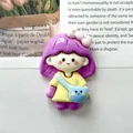 Close-up detail of a glossy resin girl figurine with purple hair and a blue bear bag - Backpack Girl - Purple Hair