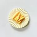 Detailed view of a miniature 3D fridge magnet shaped like a plate of yellow food. - Cheese Sticks Platter Style