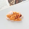 Gedetailleerd macro-beeld van een gesimuleerd croissantbrood-harsaccessoire voor DIY - Croissant