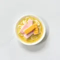 Detaillierte Makroaufnahme eines kreativen 3D Miniatur Ramen Nudel Kühlschrankmagnets - Frühstücksfleisch Nudeln Stil