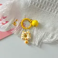 Detailed close-up view of a cute cartoon cat donut keychain with yellow ring and a bell - Yellow Spotted Cat + Yellow Ring + Yellow Bell