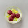 Dettaglio di un magnete da frigo in resina 3D con design realistico di dessert - Budino Verde al Corbezzolo