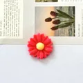 Primo piano dettagliato di un accessorio margherita in resina rossa per gioielli DIY - Rosso