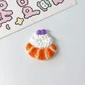 Macro view of a miniature resin pastry accessory with cream and purple berry toppings - Cream Bread