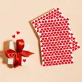 Close-up of vibrant red heart stickers sheets on a warm background with a gift box - A57 / 22x15.5cm