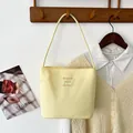 Bolso de cubo de nailon bordado estilo dopamina amarillo claro de moda para mujer al hombro - Amarillo claro con letras