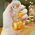 Elegant translucent orange resin apple keychain accessory with golden glitter ball charm - Aurora Persimmon Style (2026) / 1 Piece / Orange