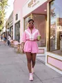 Stylish pink and white color-block two-piece lounge set worn by a model in a street setting. - Pink