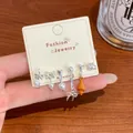Detailed view of cute earring set with croissant bow and pearl charms on a card - Croissant Party (TPT1) / Orange
