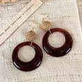 Vintage dark amber resin earrings with woven straw balls on a beige textured linen background. - Circle Hoop Earrings (28498C)