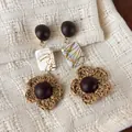 Handcrafted retro ethnic style earrings featuring dark wood studs and woven straw flowers - Shell Woven Flower Style (28499B)