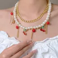Double-layered pearl and gold chain necklace featuring vibrant red cherry charms - Pearl Double Layer Cherry Necklace (4653) / Faux Pearl Decoration / KC Gold