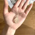 Gedetailleerde weergave van een handgemaakte ketting met gele ruwe kristalsteen - Hangerketting met omwikkelde ruwe steen (F83-3) / Citrien