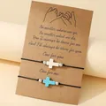 Close-up of handmade friendship bracelets with cross charms on a sentimental kraft card. - Turquoise White Stone Cross / Set of 2 / Black