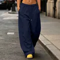 Navy blue wide-leg sweatpants with drawstring and pockets shown in a street setting - Navy Blue