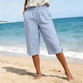 Detailed shot of women's blue and white gingham cropped pants on a sunny beach beach setting - S / Bottoms / Blue