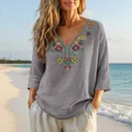 Detail view of boho grey cotton linen blouse with colorful floral embroidery on V-neck - Gray