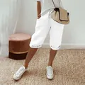 Detail of white cotton linen capris with elastic drawstring waist and side pockets - S / Bottoms / White