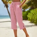 Detailed view of red and white striped cropped pants on a tropical beach setting - S / Bottoms / Red and White Striped