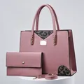 Detail view of stylish pink handbag set with matching wallet on a white pedestal - Three-Piece Set / Pink