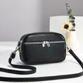 Petit sac à bandoulière noir en cuir grainé pour femme avec trois compartiments zippés. - Noir