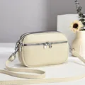 Vielseitige beige kleine Umhängetasche aus genarbtem Leder mit drei Reißverschlüssen - Gebrochenes Weiß