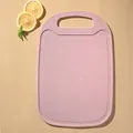 Pink wheat straw cutting board for kitchen use with anti-slip surface and handle. - Pink