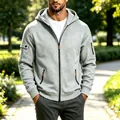 Detailopname van grijze technische herenjas met capuchon en oranje ritsdetails - M / Tops / Lichtgrijs