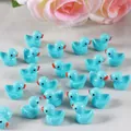 Vue macro de plusieurs canards miniatures en résine bleu clair pour micro-paysage DIY - Couleur solide Bleu clair