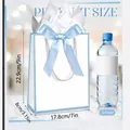 Size illustration of white gift bag with light blue bow and decorative tissue paper - 22.9*17.8*8 / Blue Frame White Paper