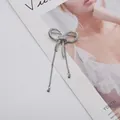 Close-up macro view of a silver metallic bow knot brooch featuring elegant hanging tassels - Tassel Bowknot