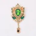 Vintage court-style green rhinestone brooch with gold hollow-out design and tassel pendant - Green