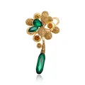 Elegant gold flower brooch decorated with green crystals and a teardrop tassel accent. - Green