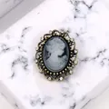 Elegant vintage grey cameo brooch featuring a crystal-encrusted gold-tone frame - Gray