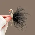 Detailed view of elegant gold flamingo brooch with sparkling crystals and black feathers - Flamingo-Black Feather
