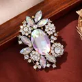 Vintage gold-tone alloy brooch featuring iridescent AB crystals and clear rhinestone flowers - White