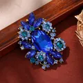 Elegant vintage style blue crystal rhinestone flower brooch pin with a gold alloy base - Blue