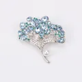 Elegant silver-toned ginkgo leaf brooch with blue crystals and a white pearl accent. - Blue