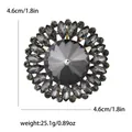 Elegant flower brooch featuring dark gray faceted crystals and shiny rhinestone details - Black