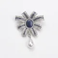 Elegante broche met franse strik voorzien van blauwe kristallen en een witte druppelparel - Strikstijl (8585) / Blauw