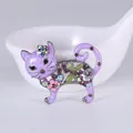 Vista dettagliata di una spilla a gatto in smalto viola con strass colorati e fiori. - Violetto