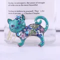 Primo piano di una spilla a forma di gatto vintage in smalto blu con strass colorati - Blu lago