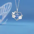 Elegante zilveren hartketting met bloemen, vlinder en blauwe centrale edelsteen - Hartenvreugde