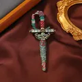 Vista macro del lujoso broche de espada de estilo corte con cristales coloridos y cabeza de águila. - Multicolor