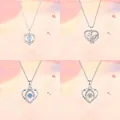 Close-up van vier zilveren hartvormige hangers met verschillende fonkelende steenontwerpen - Eenvoudige Verpakking / Vier Harten Ketting Collectie Set