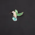 Detailed shot of an elegant hummingbird brooch with sparkling crystals and green enamel. - Emerald Green And White Rhinestone Gold Base