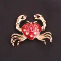 Detailed macro view of a gold-toned enamel crab brooch adorned with sparkling stones - Red Enamel Gold Crab