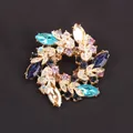 Detailed view of a vibrant floral wreath brooch featuring multi-colored rhinestones. - Gold Multicolor Flower Wreath